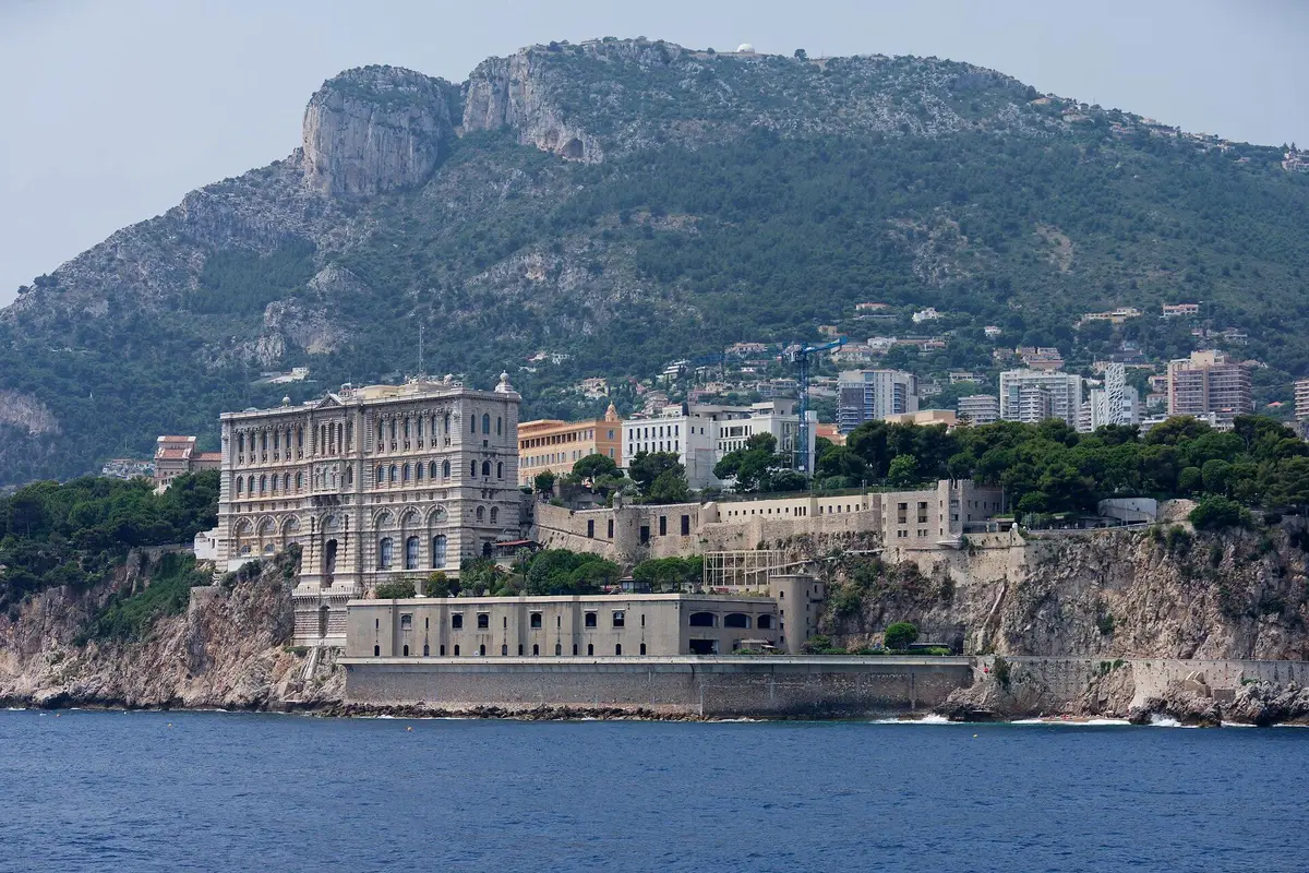 The Oceanographic Museum built into the cliff face of the Rock, seen from the water, with the mountains behind